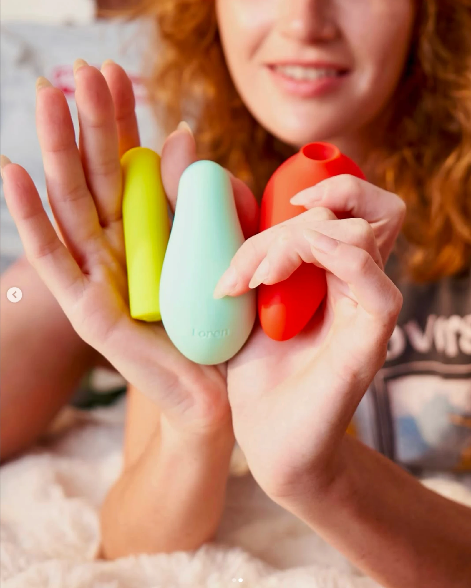 LOREN, two hands holding yellow, mint and red products in front of a smiling face