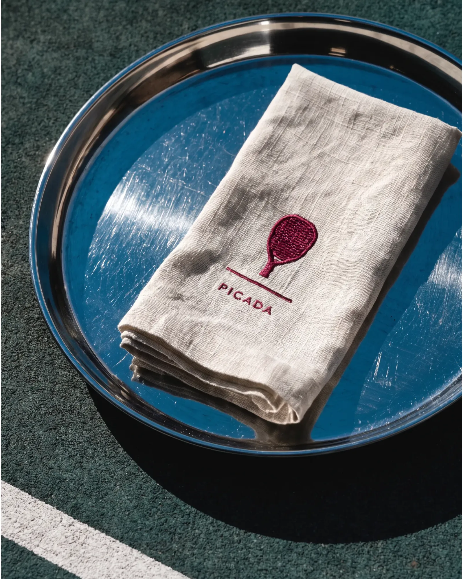 Picada, a linen napkin with the racket mark on a blue tray